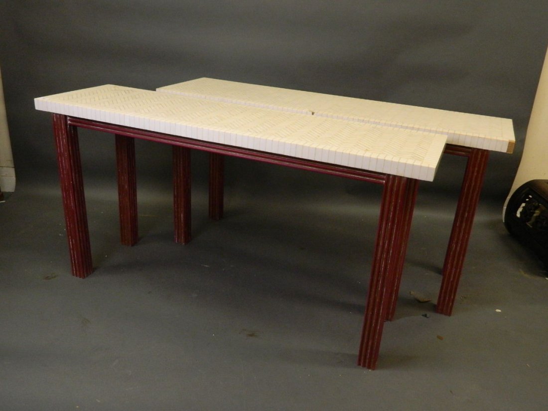 A pair of parquetry bone topped console tables on a: A pair of parquetry bone topped console tables on a lacquered and giltwood fluted base, 55" x 16", 28" high