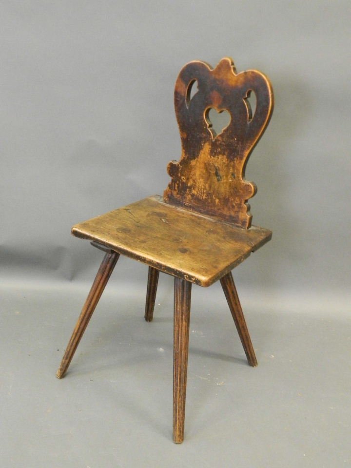 An Arts & Crafts elm and fruitwood hall chair with a: An Arts & Crafts elm and fruitwood hall chair with a carved and pierced back, on fluted tapering legs, 34" high