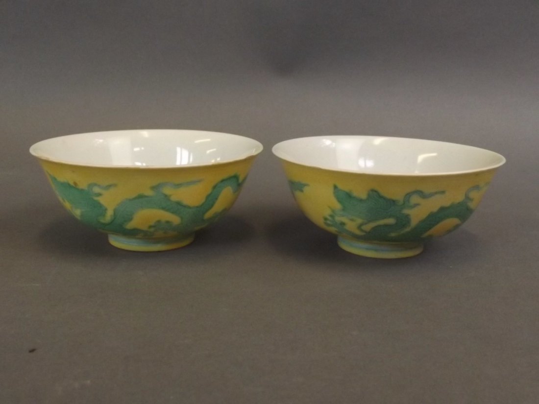 A pair of Chinese yellow ground porcelain tea bowls: A pair of Chinese yellow ground porcelain tea bowls with green incised twin dragon decoration, 6 character mark to base, 3" diameter