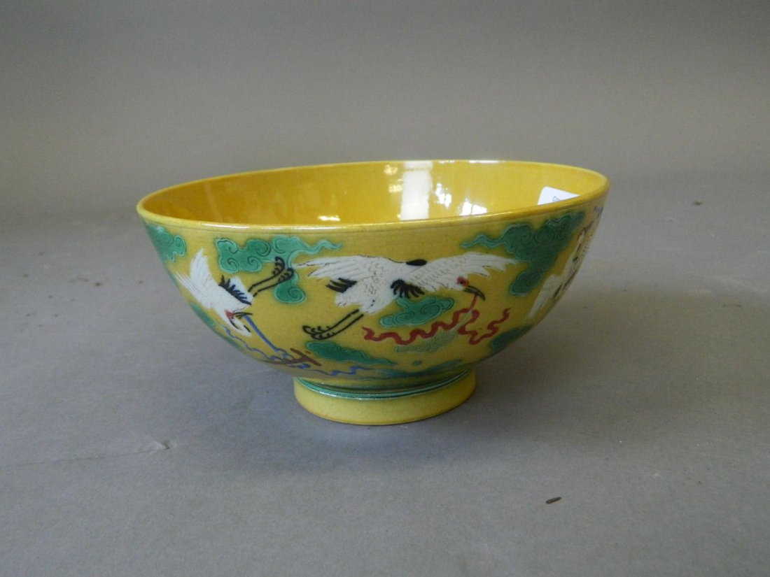 A Chinese yellow ground porcelain rice bowl with: A Chinese yellow ground porcelain rice bowl with incised and enamelled stork decoration, 6 character mark to base, 6" diameter