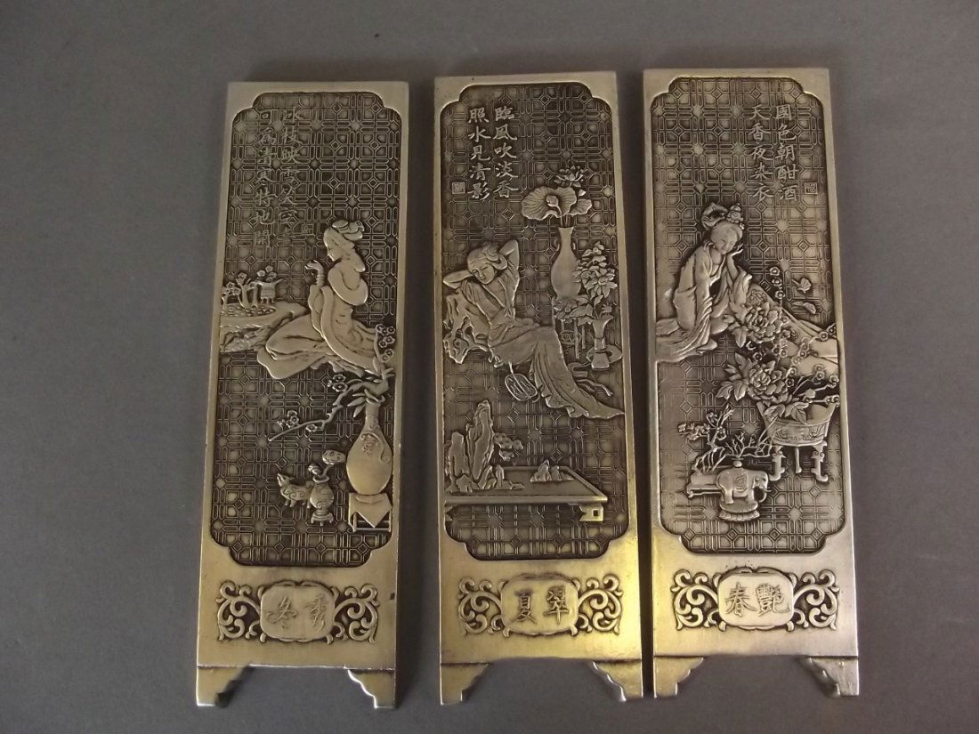 A set of three Chinese white metal scroll weights with (1 of 2)