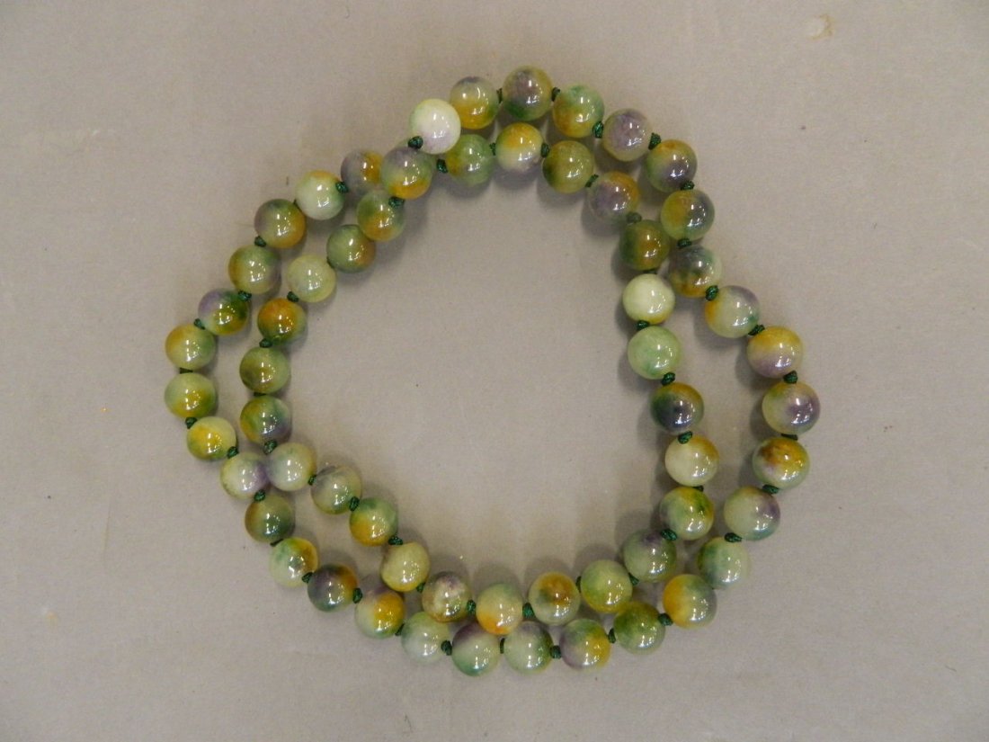 A string of tri-colour jade beads, 31" long: A string of tri-colour jade beads, 31" long