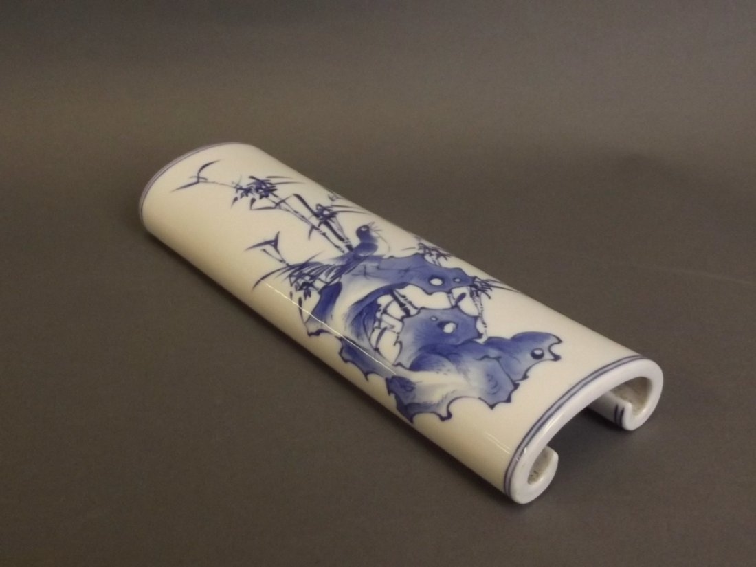 A Chinese blue and white porcelain wrist rest with: A Chinese blue and white porcelain wrist rest with painted bird and bamboo decoration, seal mark to base, 8" x 3"