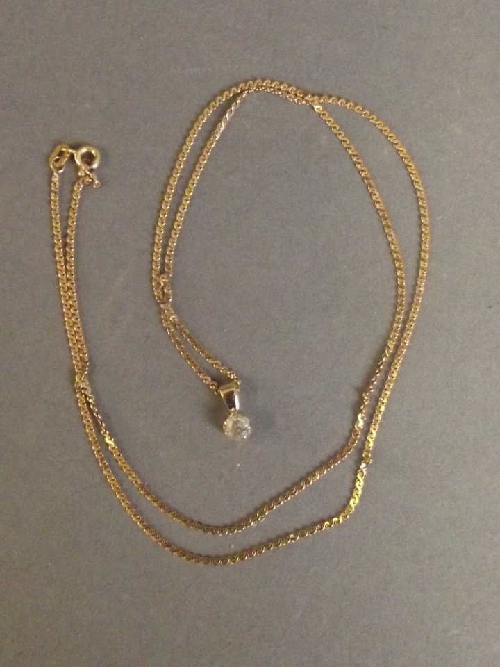 A single stone diamond pendant on a 9ct gold chain, 22": A single stone diamond pendant on a 9ct gold chain, 22" long