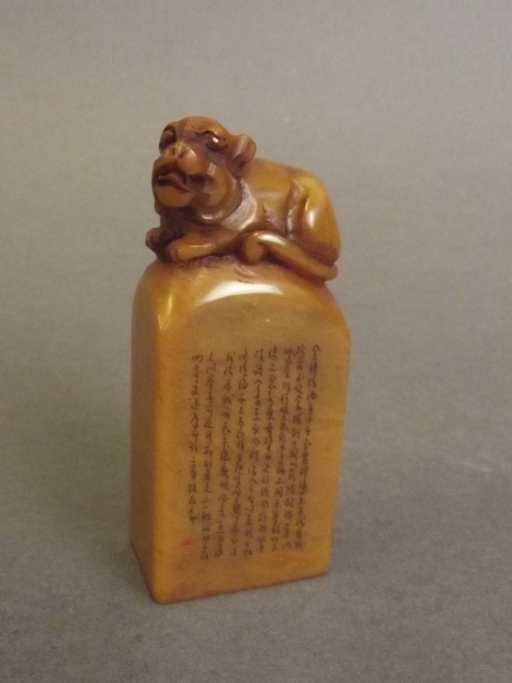 A Chinese amber soapstone seal with carved kylin knop: A Chinese amber soapstone seal with carved kylin knop and character inscription, 3" high