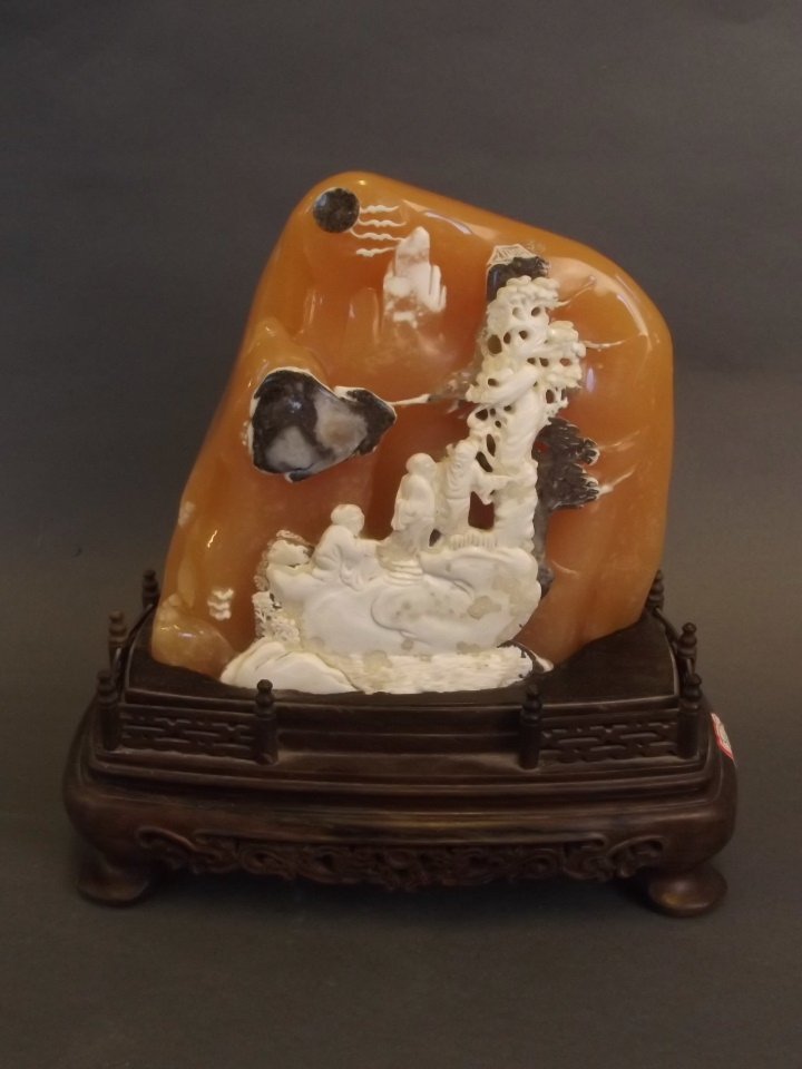 A Chinese natural soapstone carved ornament depicting (1 of 3)
