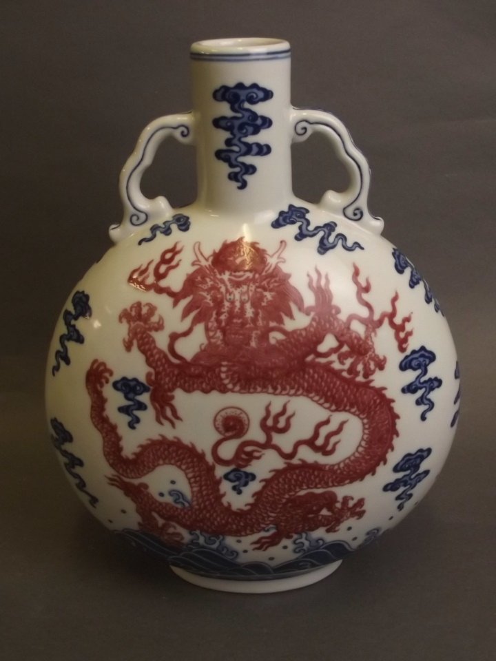 A fine Chinese blue and white porcelain twin handled: A fine Chinese blue and white porcelain twin handled moonflask with painted red enamel decoration of a dragon and the flaming pearl, seal mark to base, 11" high