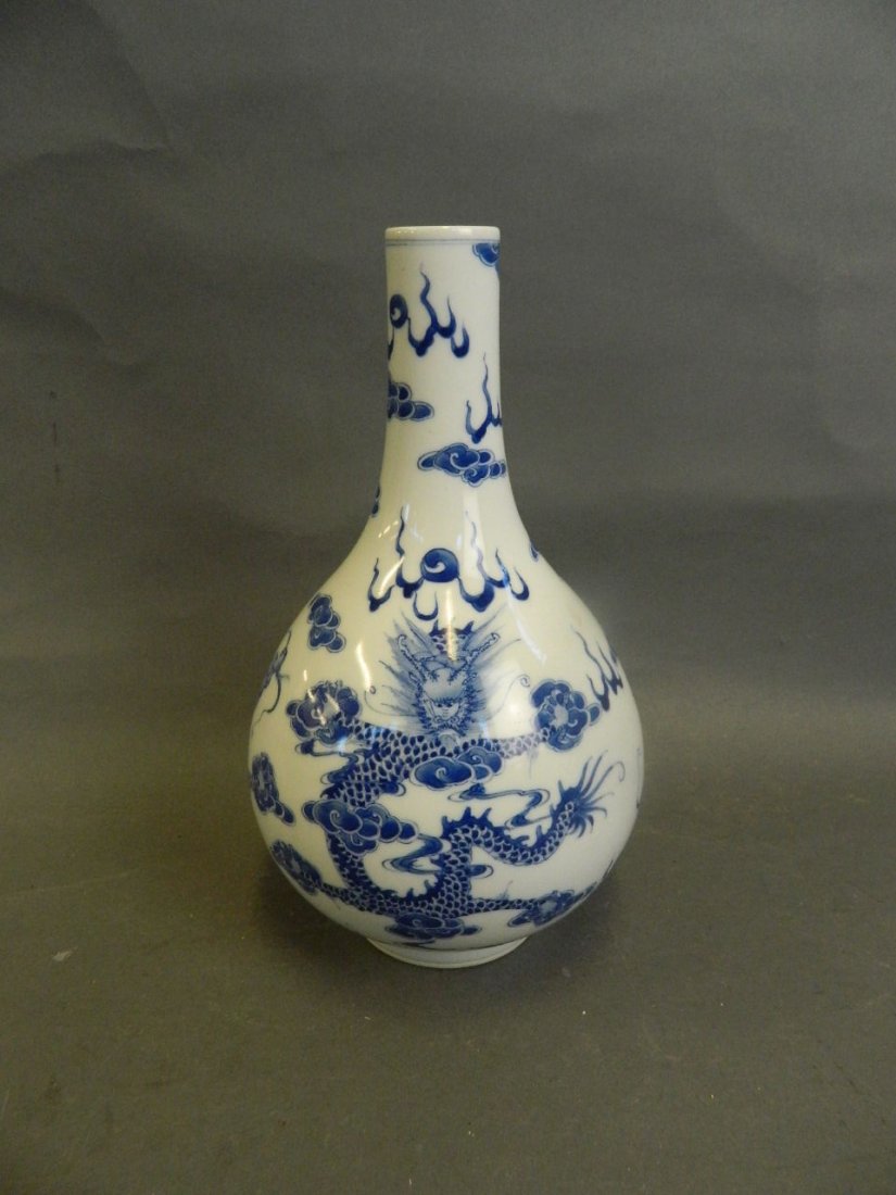 A Chinese blue and white porcelain bottle vase: A Chinese blue and white porcelain bottle vase decorated with dragons chasing the flaming pearl, seal mark to base, 11" high