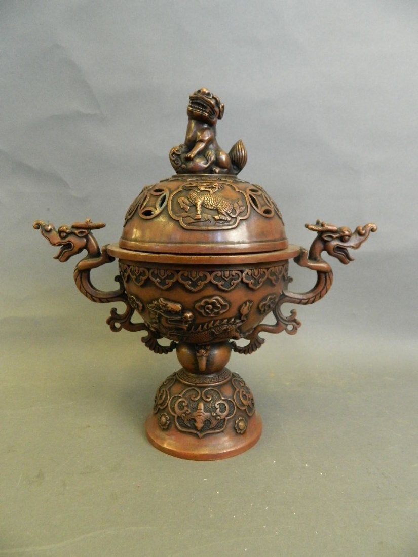 A Chinese coppered metal twin dragon handled censer: A Chinese coppered metal twin dragon handled censer with kylin surmount and raised bat and dragon decoration, 4 character mark to stem, 12" high