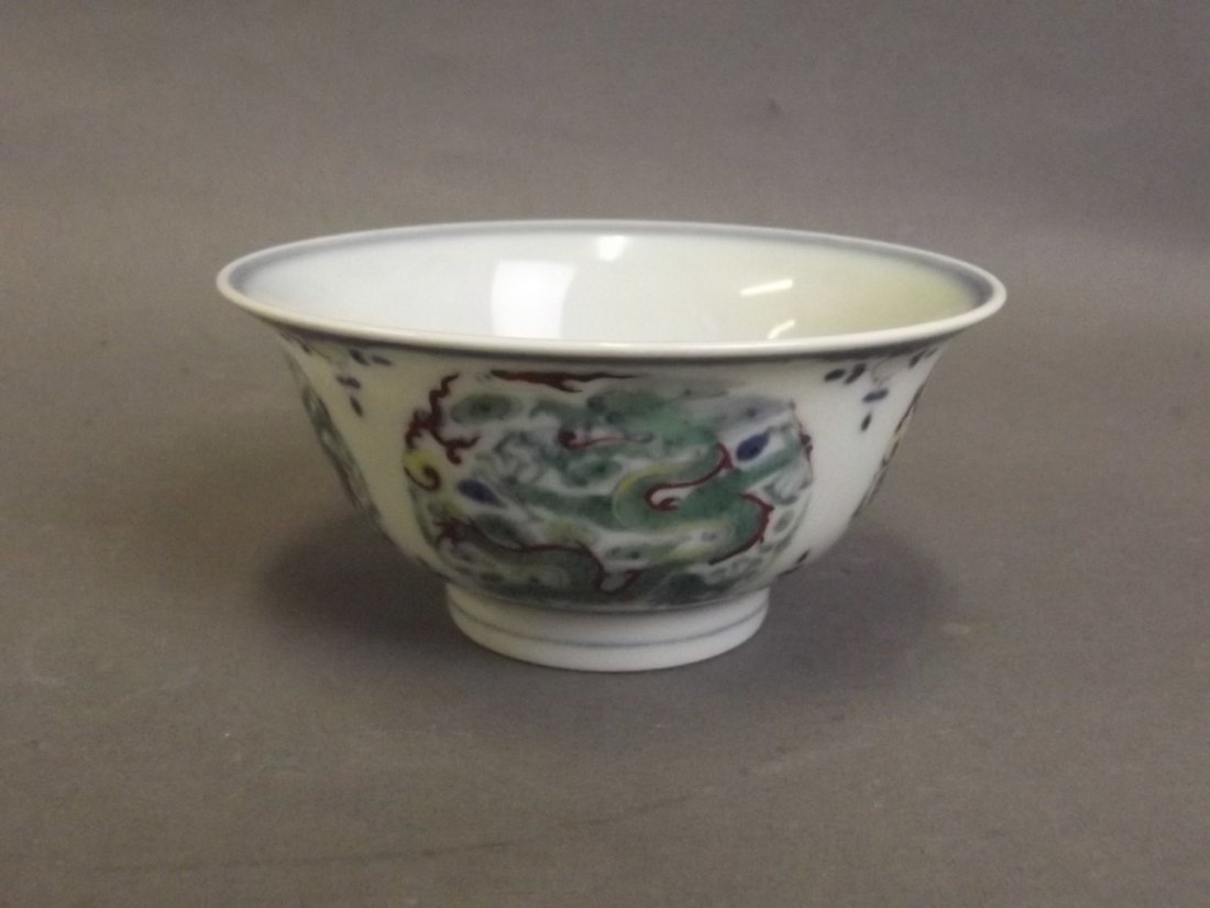 A Chinese Doucai porcelain tea bowl with dragon and: A Chinese Doucai porcelain tea bowl with dragon and flaming pearl decoration, 6 character mark to base, 4" diameter