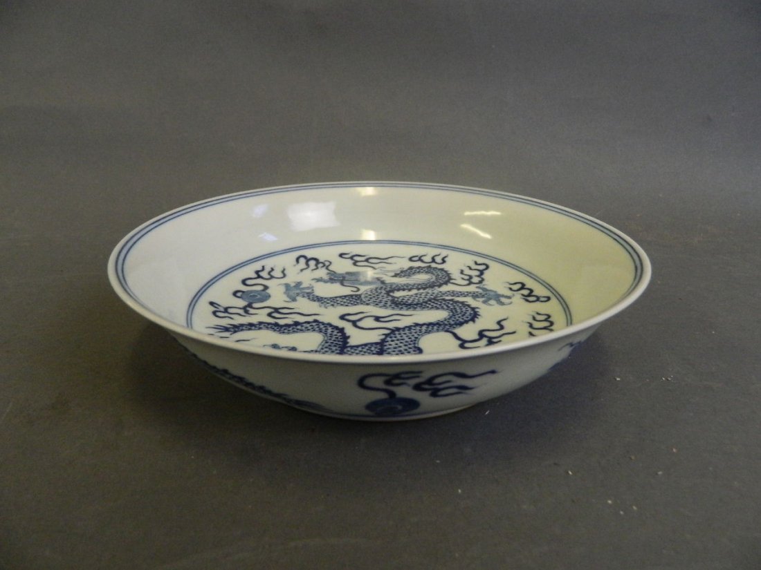 A Chinese blue and white porcelain dish with painted: A Chinese blue and white porcelain dish with painted decoration of a dragon chasing the flaming pearl, 6 character mark to base, 7" diameter