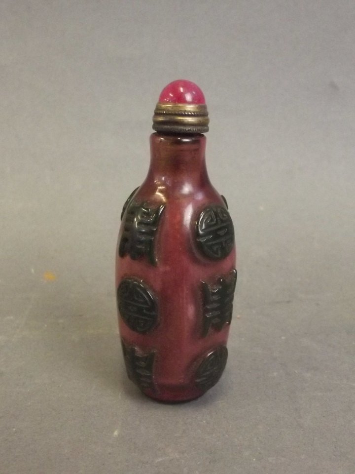 A Peking glass snuff bottle with green raised: A Peking glass snuff bottle with green raised decoration of the prosperity symbol on a pink ground, 3" high