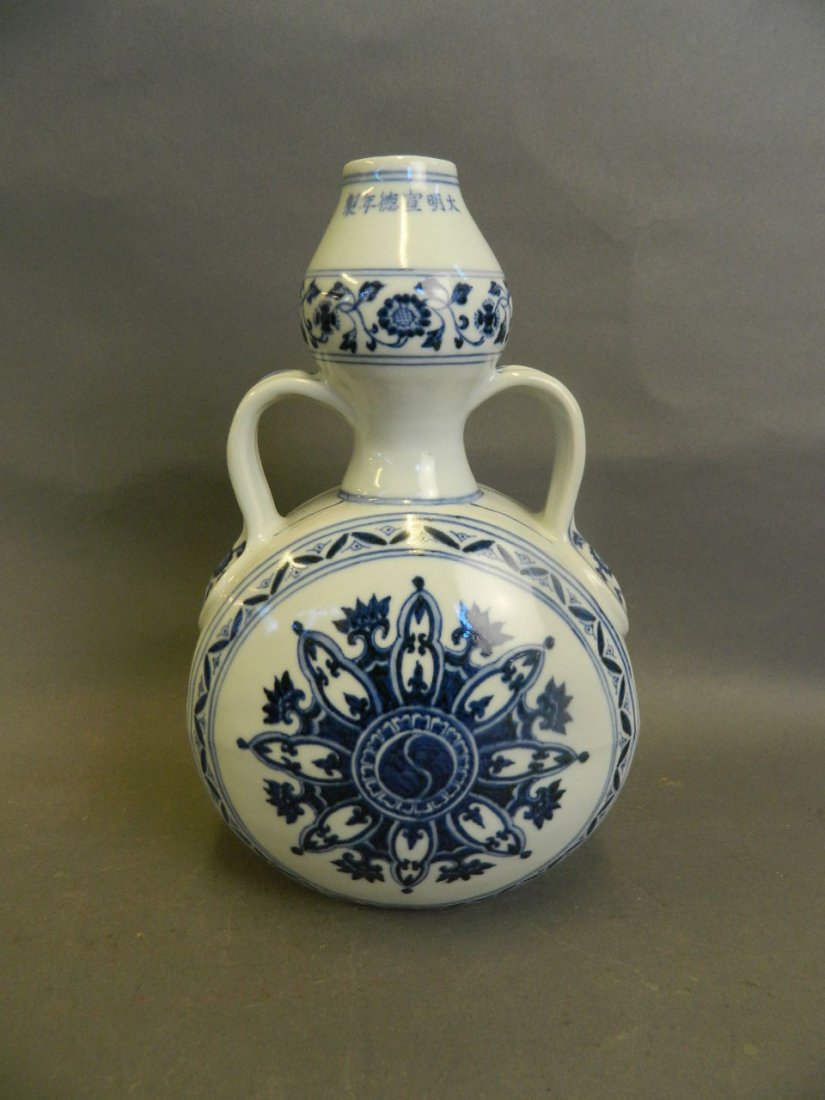 A Chinese blue and white porcelain moon flask with twin: A Chinese blue and white porcelain moon flask with twin handles and Yin & Yang decoration, 6 character mark to neck, 10_" high