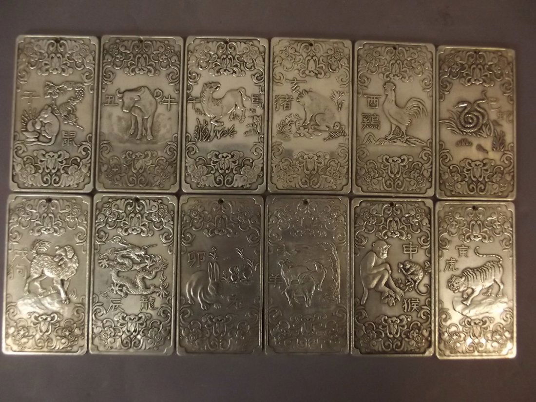 A set of twelve Chinese white metal tokens, each (1 of 3)