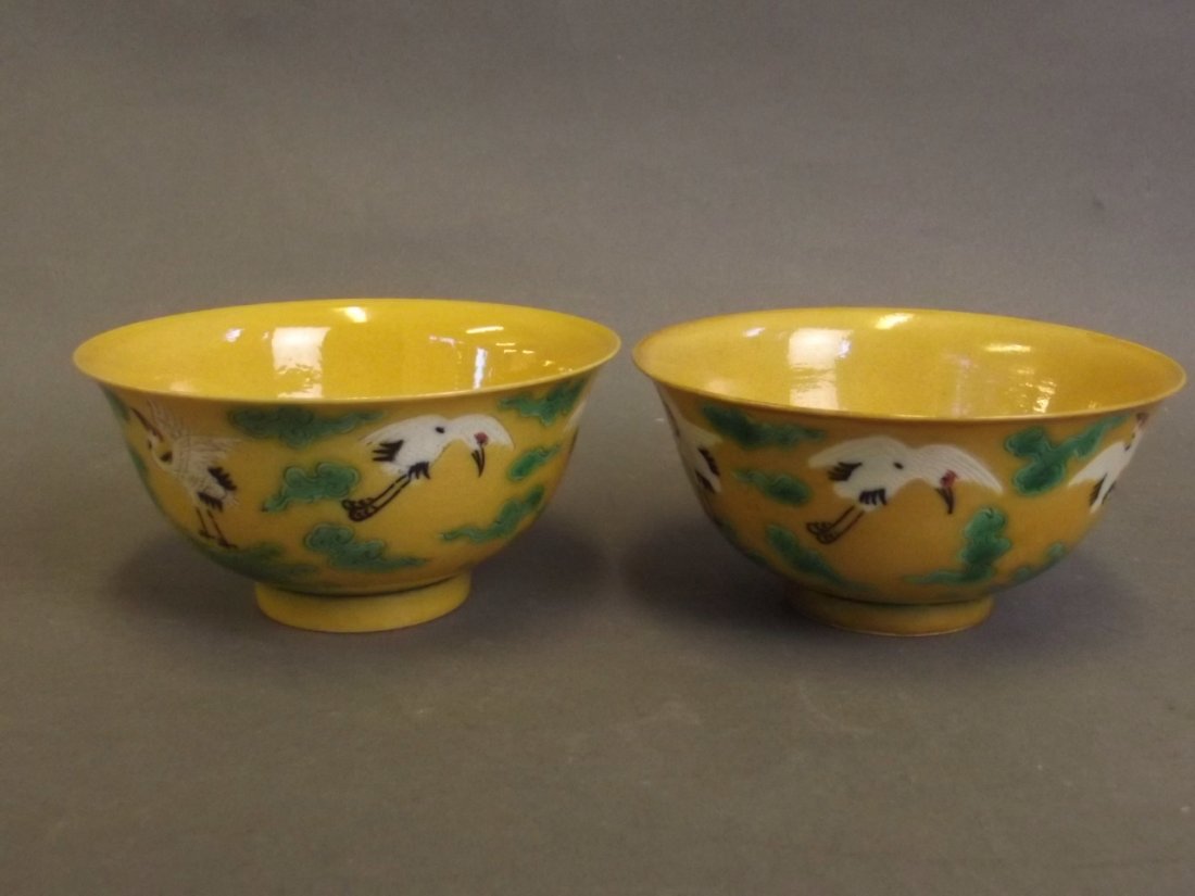 A pair of Chinese yellow ground porcelain tea bowls: A pair of Chinese yellow ground porcelain tea bowls with incised and enamelled stork decoration, 6 character mark to base, 4" diameter