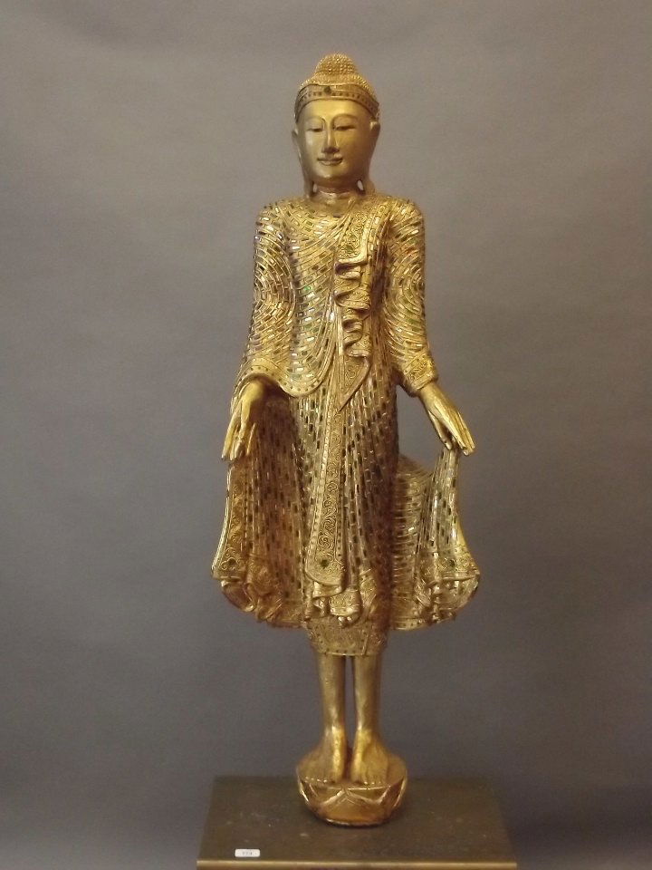 A large giltwood figure of a standing Buddha wearing (1 of 3)