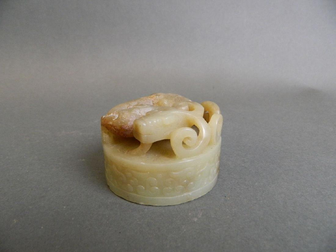 A Chinese marbled green and brown jade seal with carved: A Chinese marbled green and brown jade seal with carved and pierced dragon to knop, 2" diameter