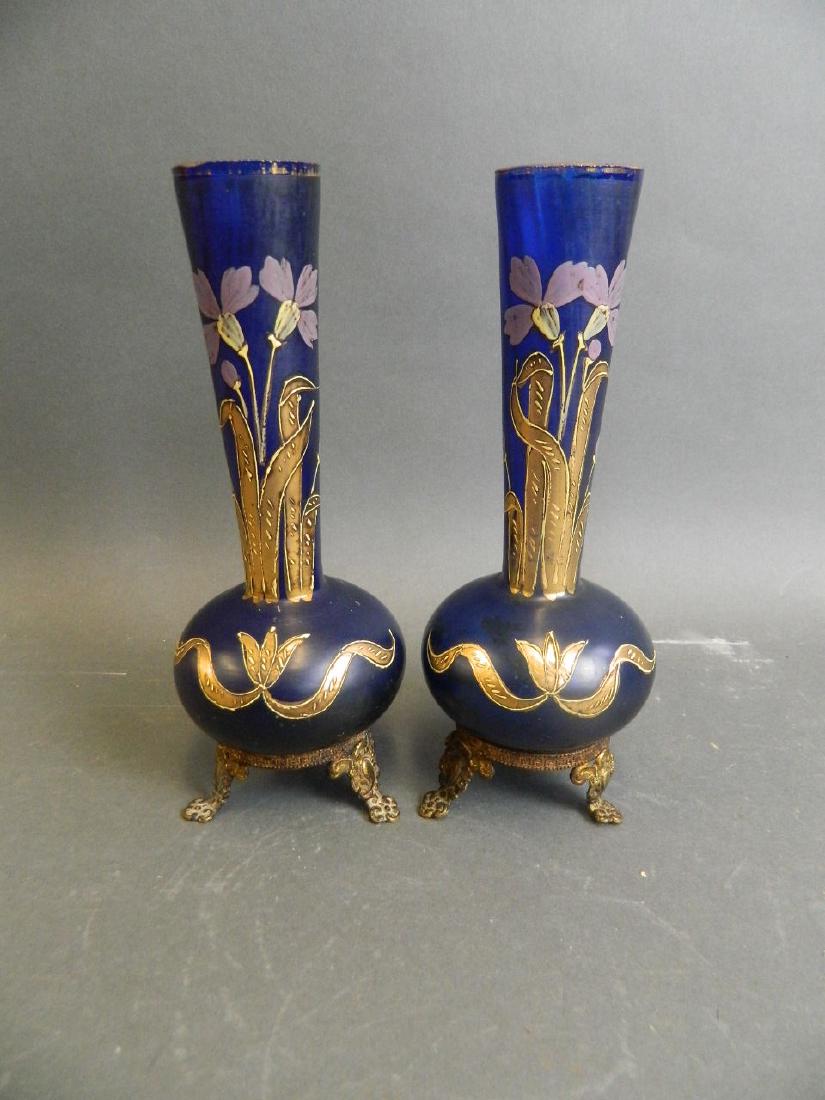 A pair of Bohemian blue glass stem vases with gilt and: A pair of Bohemian blue glass stem vases with gilt and enamel floral decoration, mounted on ormolu stands, 8" high (AF minor chip to lid)