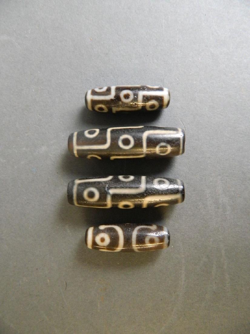 Four Chinese enamelled glass lozenge shaped beads: Four Chinese enamelled glass lozenge shaped beads decorated in the archaic style, largest 2"