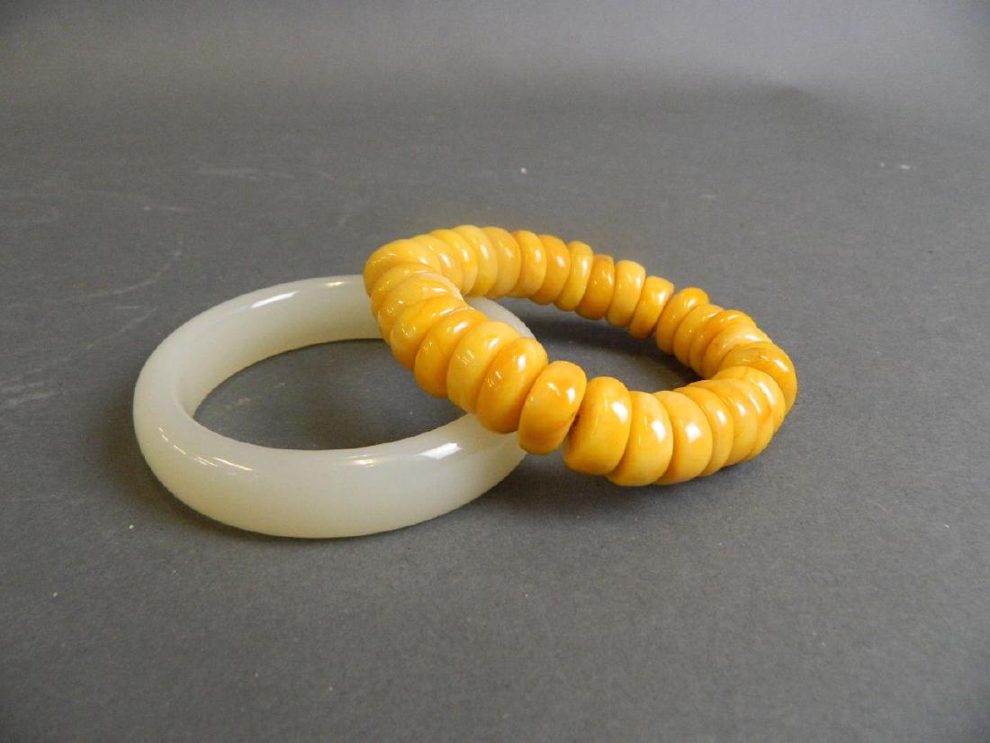 A cream jade bangle, together with an amber style bead (1 of 1)