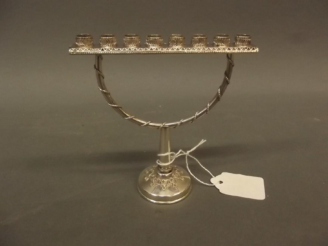 A small silver menorah candlestick, impressed 'Made in: A small silver menorah candlestick, impressed 'Made in Israel' with Hallmarks, 5" high