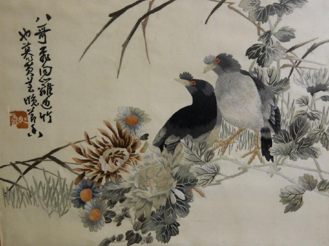 A framed Chinese silk embroidery of two birds amongst (1 of 2)
