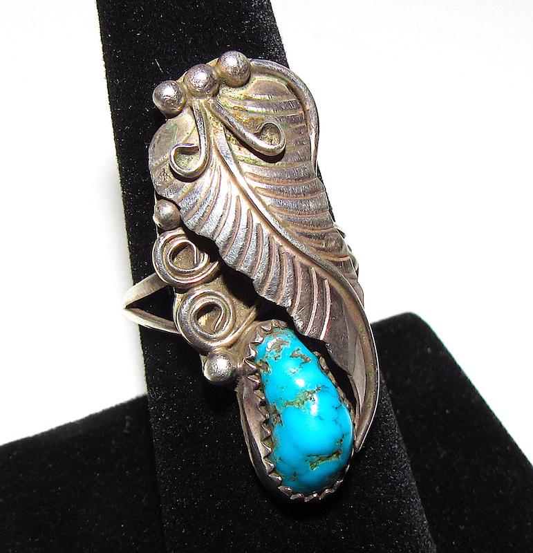 Vintage Navajo Sterling Turquoise Ring Sz. 7: Vintage Navajo Sterling Turquoise Ring Sz. 7. Squash Blossom Desing. Singed H, marked, tested. 1.5" tall on the front.