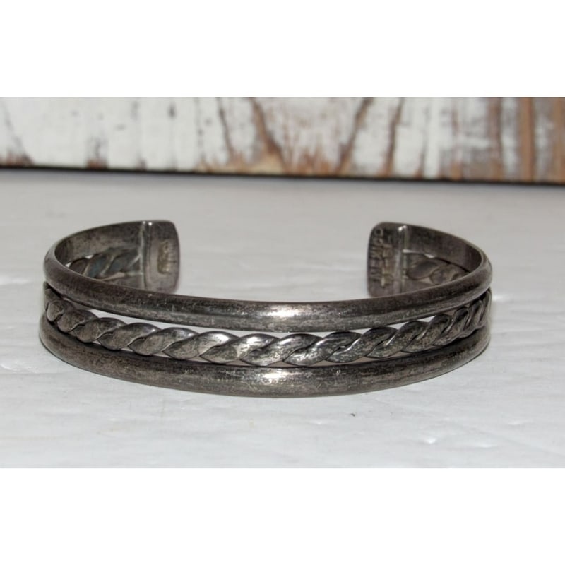 Vintage Taxco Mexican Sterling Silver Cuff Bracelet: This Taxco Mexican sterling silver cuff bracelet features a clean, modernist design highlighted by a central twisted rope detail framed by smooth silver bands. Crafted in sterling silver and stamped,