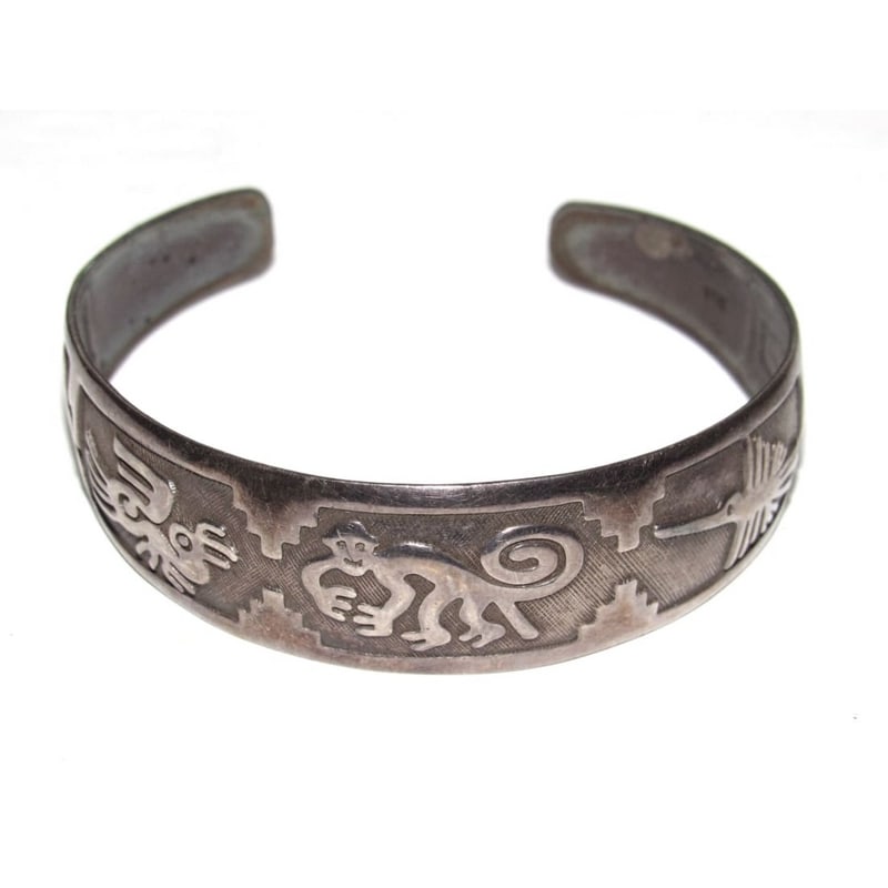 Vintage Southwestern Peruvian Sterling Silver Animal Motif Cuff Bracelet: Vintage Peruvian Sterling Silver Cuff Bracelet featuring finely engraved pre-Columbian-inspired animal motifs, including stylized monkeys and geometric stepped designs reminiscent of ancient Andean an