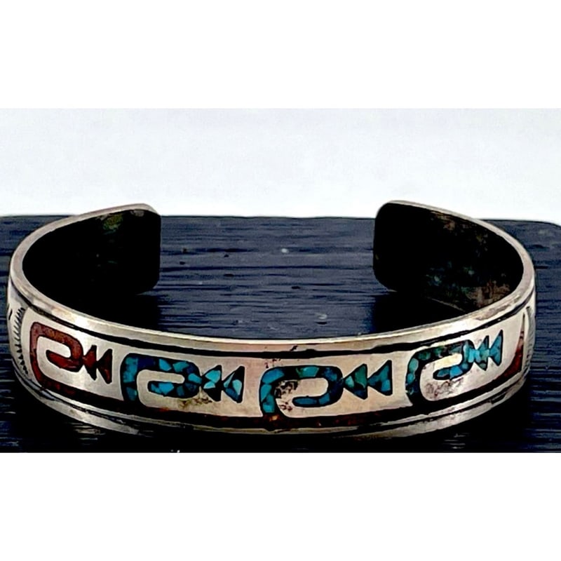 Vintage Navajo Sterling Silver Turquoise Chip Inlay Cuff Bracelet Signed: Vintage Navajo sterling silver cuff bracelet, featuring turquoise & coral inlay set within a flowing stamped arrows tribal design. The inlay adds color and movement to the silver cuff, reflecting trad