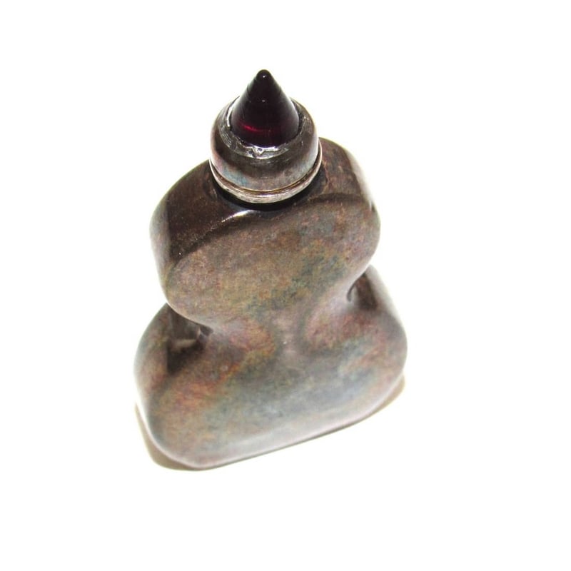 Vintage Mexican Silver Perfume Bottle with Garnet Accent: Vintage Mexican silver perfume bottle featuring a sculptural form topped with a deep red garnet finial. In Mexican and Mesoamerican tradition, garnet is often associated with vitality, protection, and