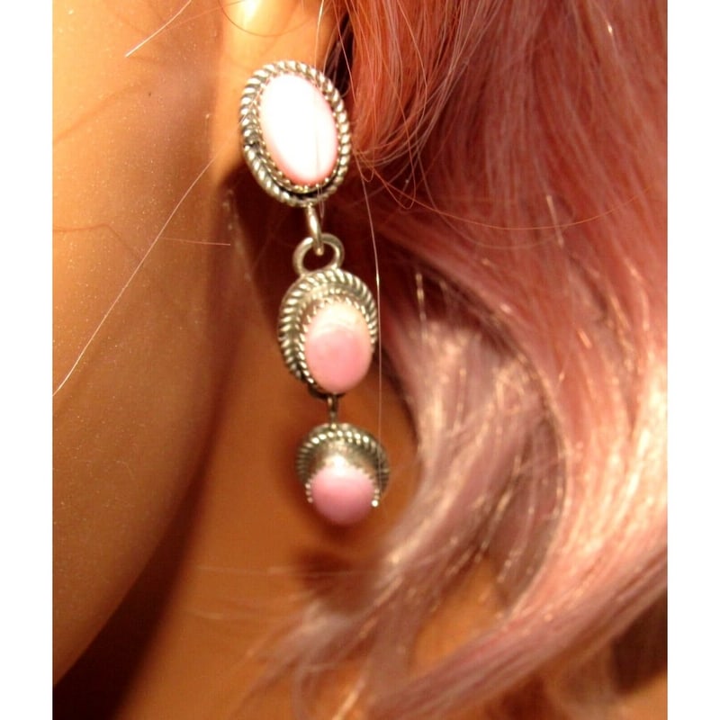 Navajo Sterling Silver Pink Conch Shell Dangle Earrings Sterling Silver T Long: Adorn yourself with the captivating allure of Navajo craftsmanship through these exquisite Pink Conch Cluster earrings by the Navajo artist Tia Long. Crafted in sterling silver, these dangle-style ear
