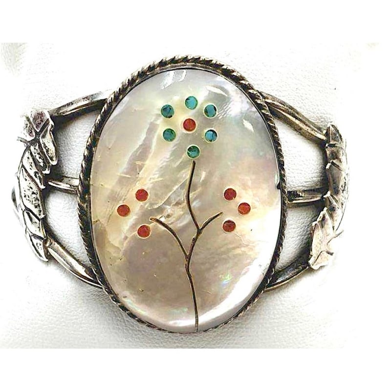 Vintage Zuni Sterling Silver Mother of Pearl Flower Inlay Cuff Bracelet: Offered is a striking vintage Zuni sterling silver cuff bracelet featuring a luminous mother-of-pearl centerpiece exquisitely inlaid with a graceful floral motif in vibrant turquoise and coral tones. 