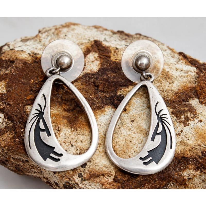 Vintage Navajo Sterling Silver Kokopelli Dangle Earrings: Vintage Navajo Sterling Silver Kokopelli Dangle Earrings. A striking pair of vintage Navajo sterling silver dangle earrings featuring the iconic Kokopelli figure rendered in a dramatic oxidized silhou