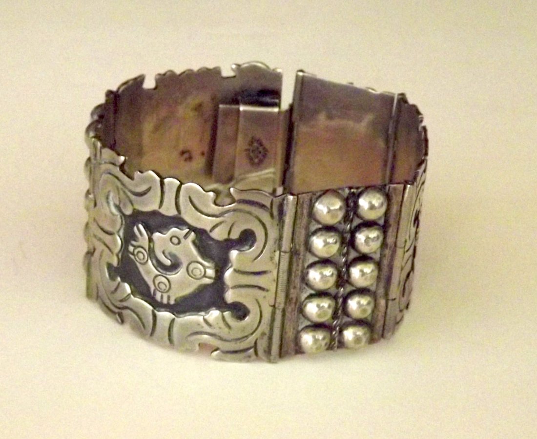 ANTIQUE/VINTAGE STERLING SILVER BRACELET: ANTIQUE/VINTAGE MEXICAN STERLING SILVER BRACELET WITH AZTEC DESIGN. THE STUNNING PIECE MEASURES 7 1/2" LONG BY 1 1/2" WIDE. THE CLASP WORKS LIKE A CHARM