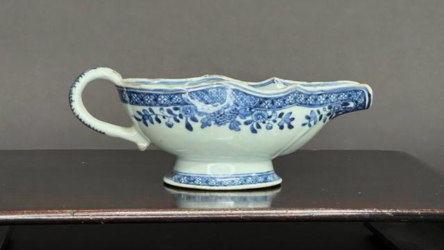 19TH CENTURY CHINESE BLUE AND WHITE GRAVY BOAT: Painted on the exterior with blooming flowers, and flanked by a handle. H: 3 1/4 in. L: 9 1/4 in. Part of the collection of Mrs. Daisy Lintilhac