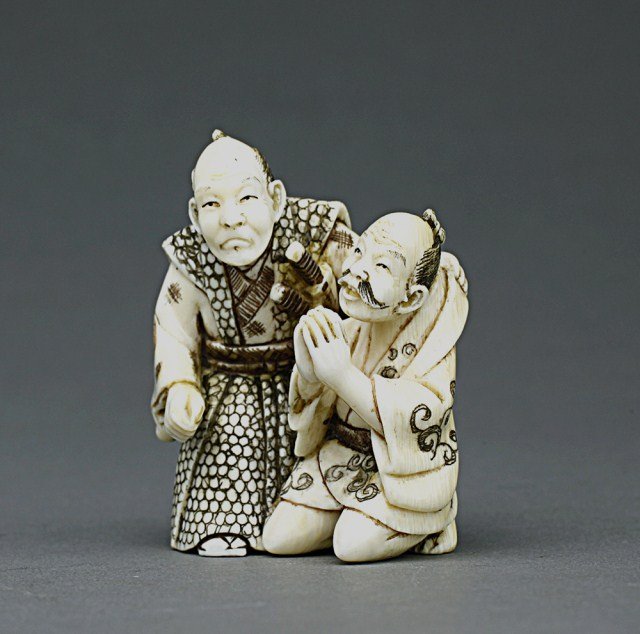 JAPANESE CARVED IVORY NETSUKE OF A SAMURAI: From the Private collection of Mr. Paul Siegal. Depicting a samurai and an old man. H: 1 3/4 in.