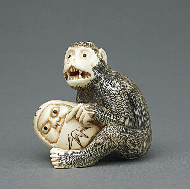 JAPANESE CARVED IVORY NETSUKE OF A MONKEY: From the Private collection of Mr. Paul Siegal. Signature on the base. H: 1 3/4 in.