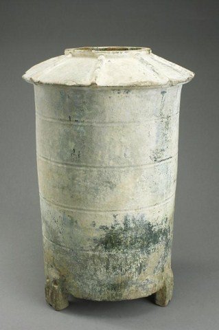 TALL CHINESE EARTHENWARE TRIPOD GRANARY: Han Dynasty of a tall cylindrical form with a sloped rim, the body with four incised rings, traces of green glaze can be seen. H: 14 1/2 in.