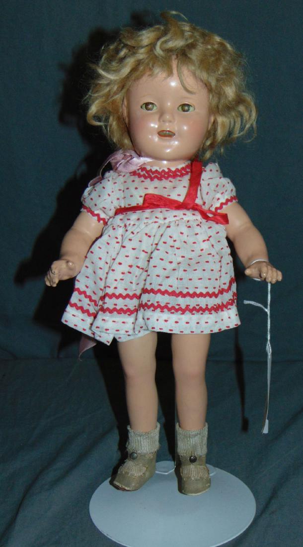 Ideal 16" Shirley Temple Composition Doll: Composition doll, approx. 16" tall. Sleep eyes, open mouth, molded teeth. Some scuffing to the limbs, and facial rubs. Examine