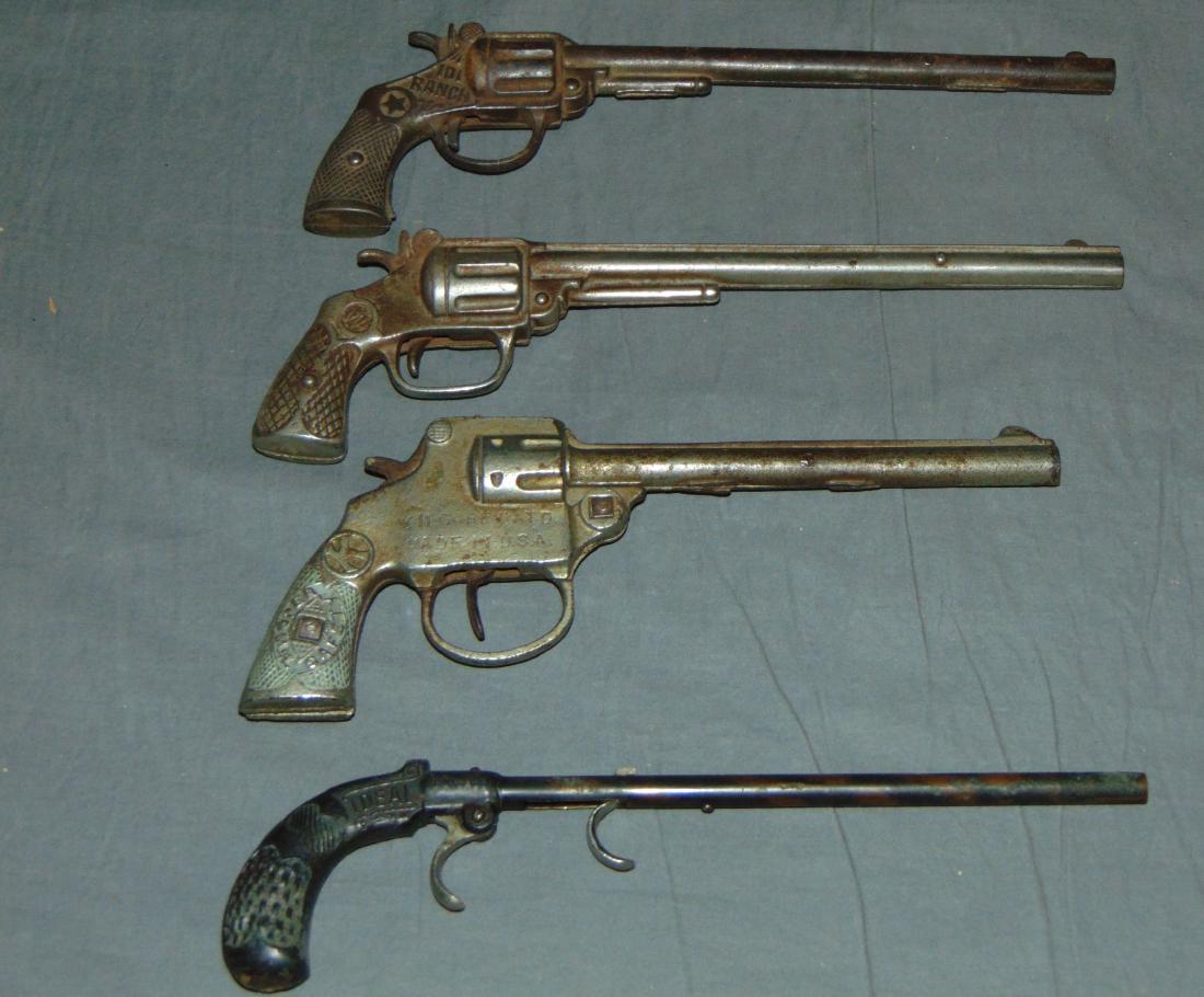 (4) Cast Iron Long Barrel Cap Guns: Includes 101 Ranch, Burke & James Ideal Flash Gun, Kilgrore Trooper Safety, and another. All are single shot, and each is in working order except for the Kilgore Trooper. Wear to each. Examine.