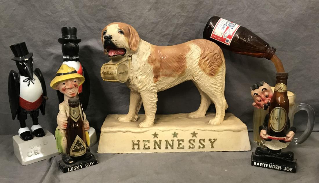 Beer & Liquor Advertising Collectible Lot: Includes Ballatine Bartender Joe (7") and Blatz Lucky Guy (7.5"), (2) Old Crow pieces, Budweiser piece, and Hennessy Dog. Some wear to each.