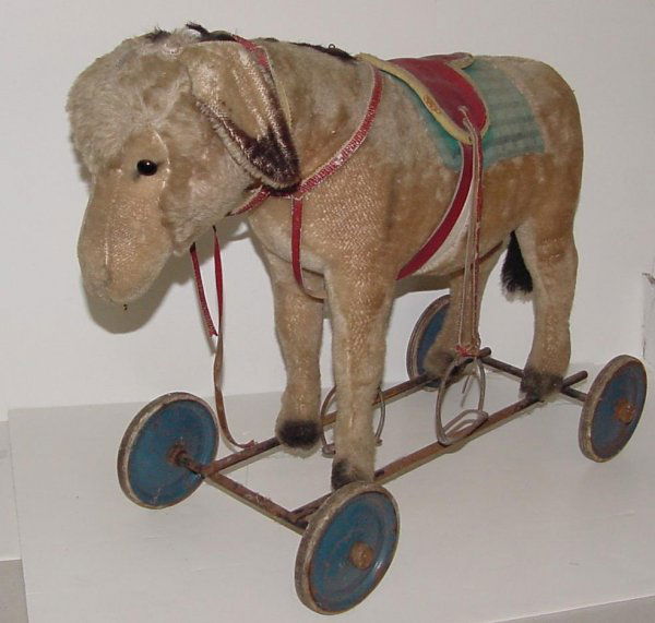 STEIFF RIDE ON DONKEY: GROWLER IS NOT FUNCTIONING. 22" LONG 20" HIGH. SIGNS OF WEAR TO STAND AND SADDLE. HAS SOME TEARS AND AREAS OR MISSING HAIR. DONKEY IS NICE.