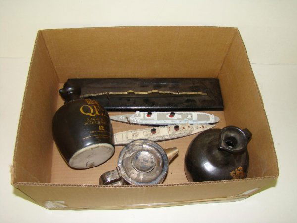 QUEEN ELIZABETH COLLECTIBLES LOT: FROM THE ESTATE OF KEN SCHULTZ. ITEMS FEATURING THE QUEEN ELIZABETH AND QUEEN ELIZABETH 2. LOT INCLUDES TWO SCOTCH WHISKY JUGS, THREE SHIP MODELS AND A SERVING CONTAINER. ALL WORN FROM AGE, MOSTLY GOO