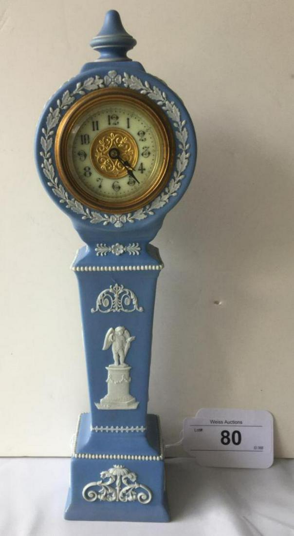 Wedgwood Blue Jasper Dip Shelf Clock,: Pedestal form with urn finial, the brass and porcelain dial with Arabic chapter with brass works by British United clock Co., Birmingham, England. The case with applied classical white figures, beadin