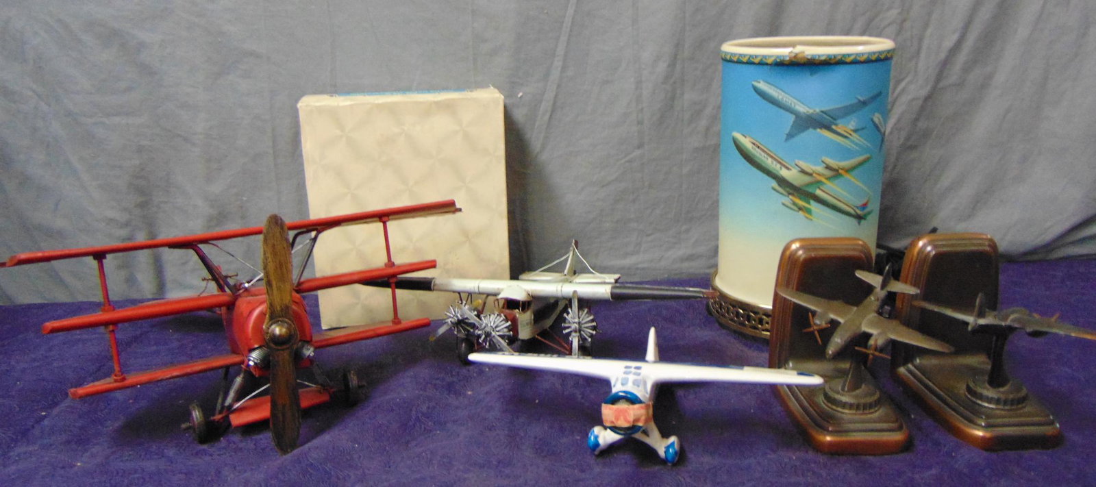 Assorted Airplane Related Items: Includes a pair of Banthrico book ends; Motion lamp, working; 2 folk art metal plane sculptures; boxed Avon Spirit of St louis; Licquor bottle. Examine.