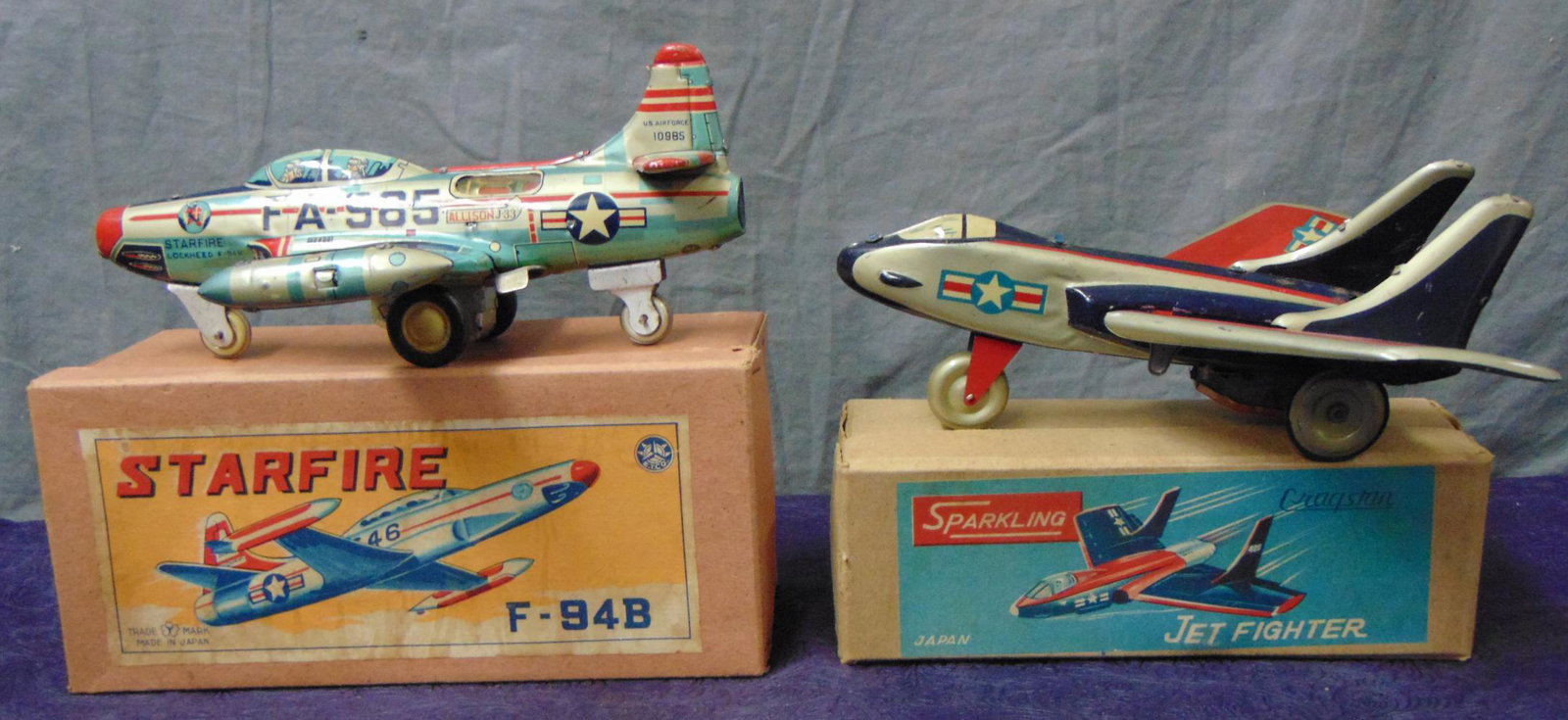 2 Boxed Early Japanese Toy Jets: Includes a Cragstan Sparkling Jet Fighter, tabs on wings are intact for a change, 8” long; Yone Starfighter F-94B, 8.5” l. Both are friction drives and show light playwear with nice boxes.