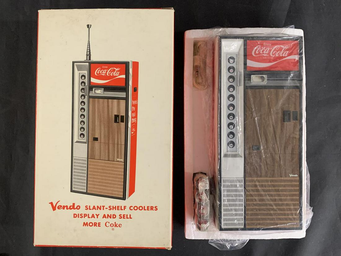Coca Cola Vendo Figural Transistor Radio, NIB: New in Box, Coca Cola Vendo Figural Radio. 9 Transistor, 2 Band, AM/FM. Includes original batteries and headphones. Never used. Comes in the original box. Box shows some edge and corner wear with ligh