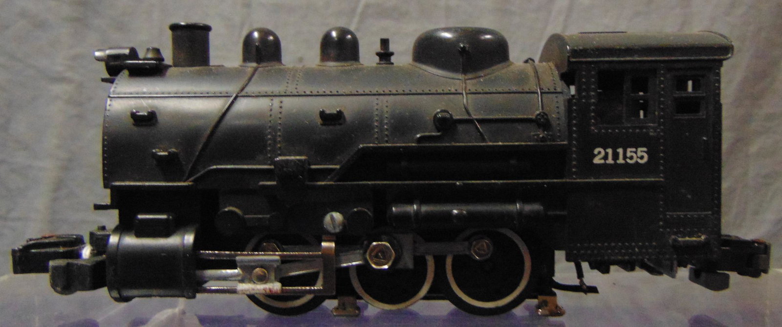 American Flyer 21155 Dockside Switcher: S Gauge. Fairly clean example with headlight, smoke & 2-position reverse. It is intact, with minor side rod oxidation and 2 pick-up show rust. It shows light playwear. From the Frank Pisani Collection