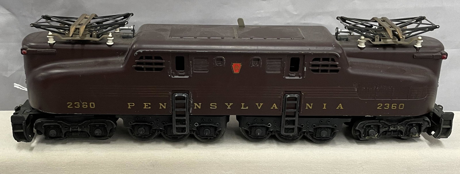 Clean Lionel 2360 PRR GG1 Electric: Clean dual motor GG1, circa 1956. The stripes are intact and complete, but a little dull one side, 50% the other. Decals are intact and battery box appears clean. It has original pantographs and insul